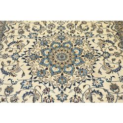 Central Persian Nain hand-knotted carpet, ivory field with central radiating medallion, issuing an all-over design of scrolling vines, palmettes, and delicate floral sprays with conforming spandrels, enclosed by a foliate border, framed by multiple guard stripes, with cotton fringe ends 