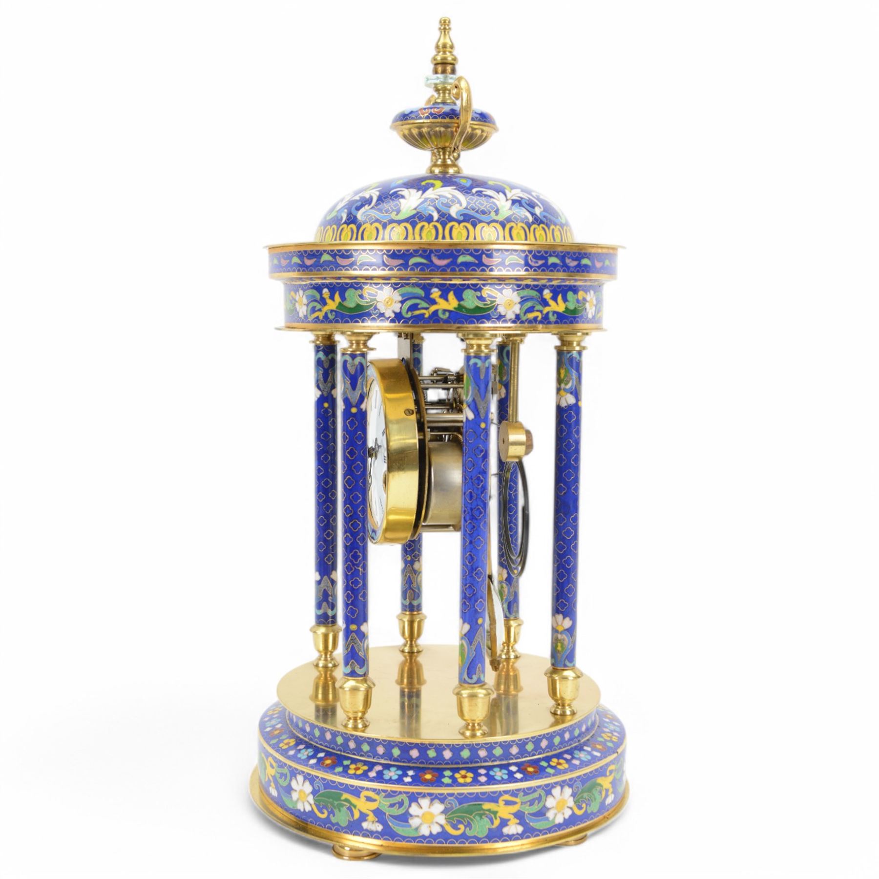 20th century- 8-day cloisonne styled rotunda clock, with six decorative enamel pillars and floral decoration to the base and top, visible pendulum with a portrait depiction of a young lady, four inch enamel dial with Roman numerals, minute markers and trefoil steel hands, twin train spring driven rack striking movement sounding the hours and half hours on a coiled gong.   