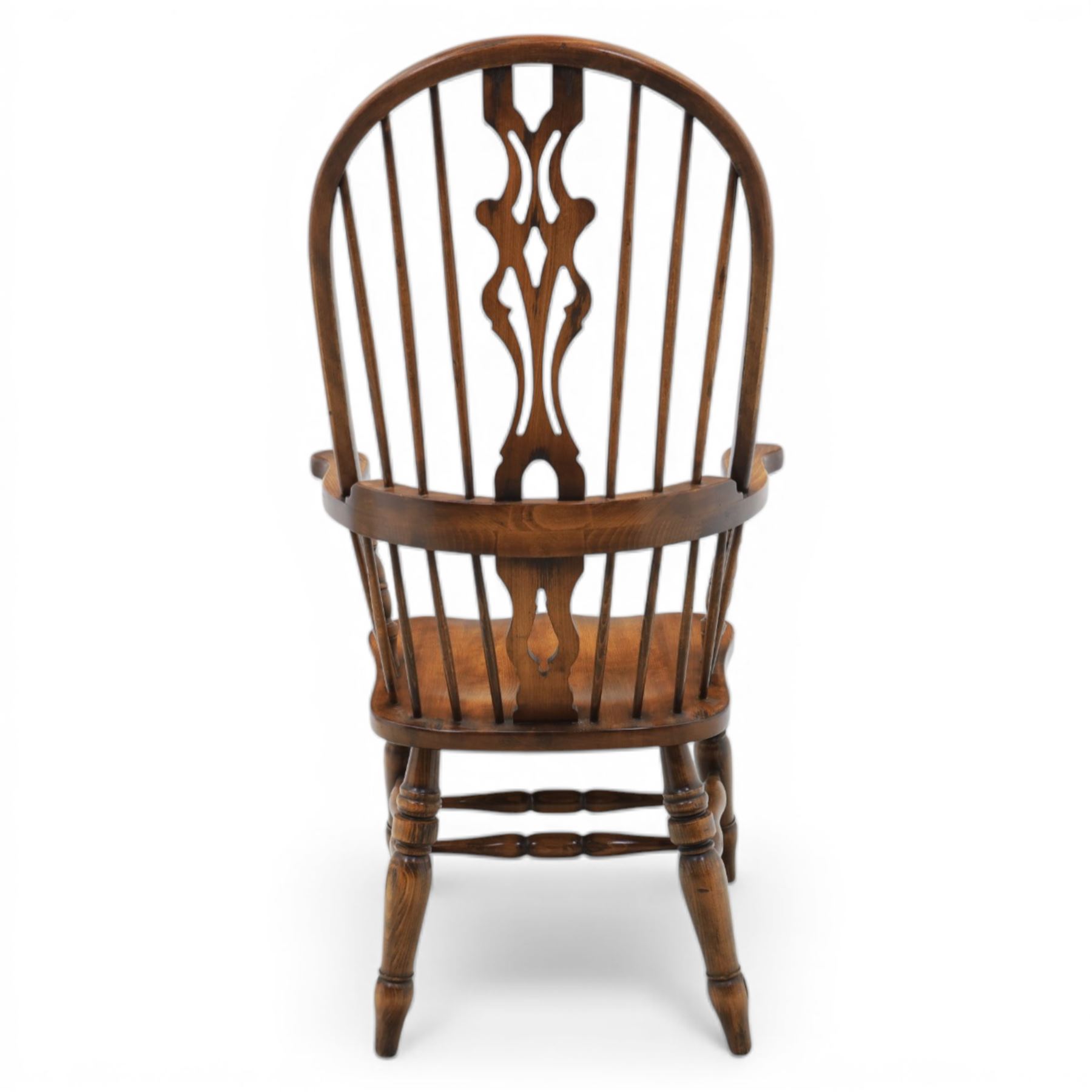 Late 20th century elm and beech high back Windsor armchair, the arched hoop back with pierced vase shaped splat between turned spindles, shaped arm rail on turned supports, saddle seat, raised on turned legs united by a crinoline stretcher