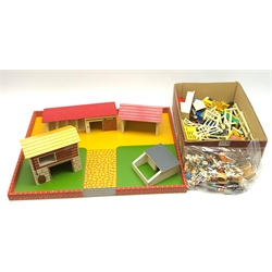 Farmyard layout including large walled wooden base board 61 x 45cm with various wooden buildings and plastic accessories, die-cast tractors and farm machinery by Britains, Ertl etc, plastic farm animals and figures by Britains etc