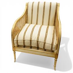 Louis XV design cream painted and parcel-gilt bergere armchair of large proportions, high scrolled back over canework arms, upholstered in striped fabric with over-stuffed loose seat cushion, on fluted supports