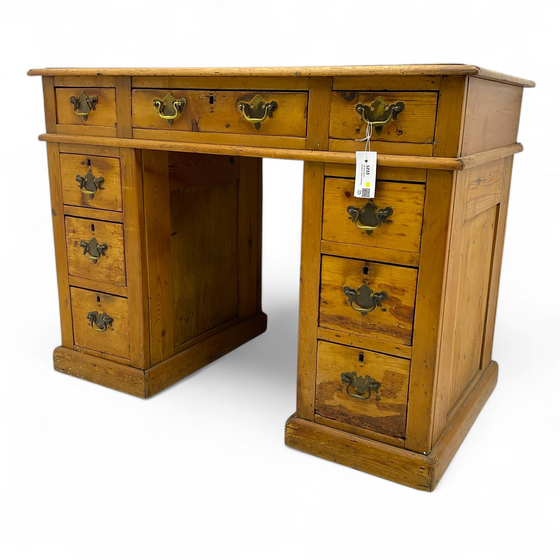 Rustic pine twin pedestal desk, rectangular green leather inset top above a central frieze drawer flanked by two short drawers, each pedestal featuring three graduated drawers, raised on a plinth base