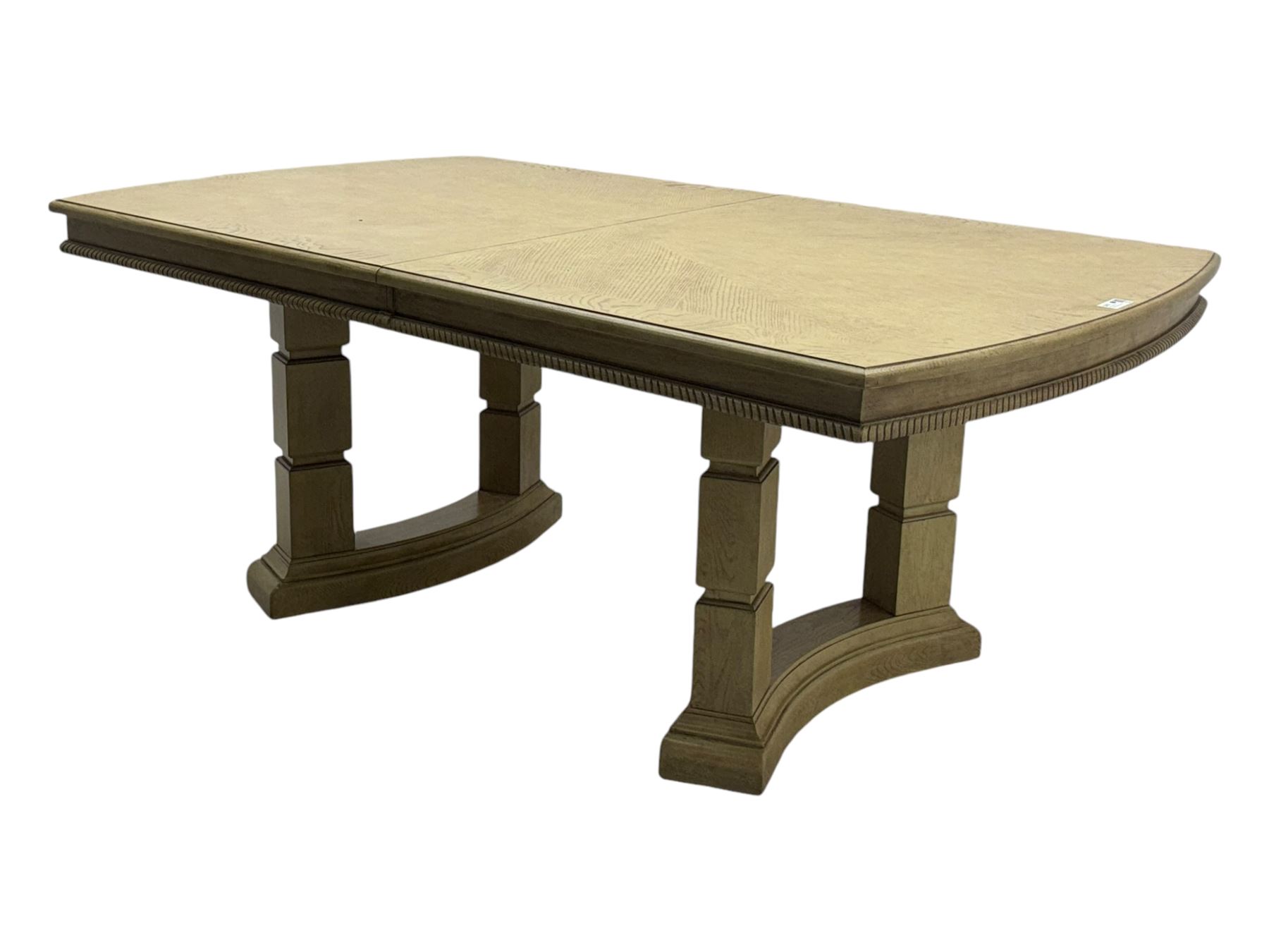 Brunswick - washed oak finish extending dining table, rectangular top with curved ends and carved frieze, central extension leaf, raised on twin pedestals with arched plinth bases and square-sectioned column supports; set of eight (6+2) high-back dining chairs upholstered in beige velvet fabric