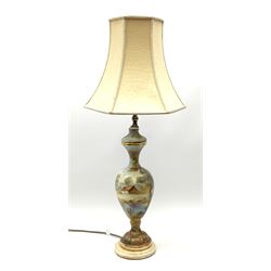 A hand painted table lamp, of baluster form decorated with landscape scene, with fabric shade, overall H76cm.