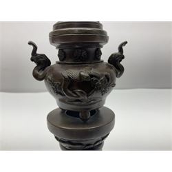 Pair of Oriental brass twin-handled incense burners, decorated in high relief with stork and turtle, the removable pierced cover with foo dog final, upon tapering cylidrical base, H23.5cm