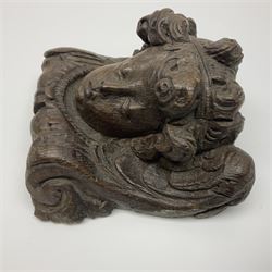 Late 17th century oak ecclesiastical wall plaque, depicting a putti mask, together with a similar 18th century wall bracket, tallest H18cm, W15.5cm
