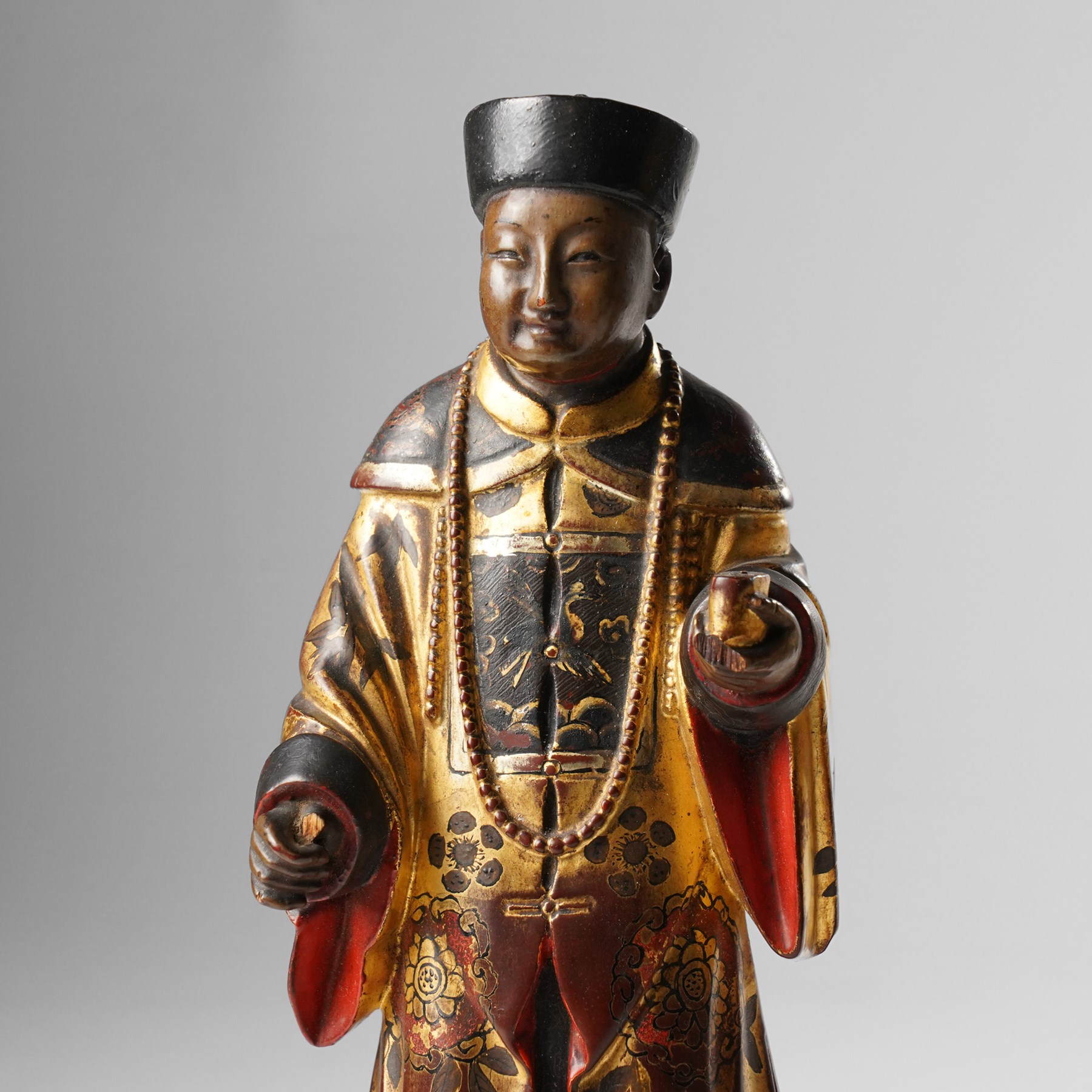 Pair of Chinese carved wooden lacquered figures, in ceremonial dress, possibly wedding attire, highlighted throughout in gilt, H22cm