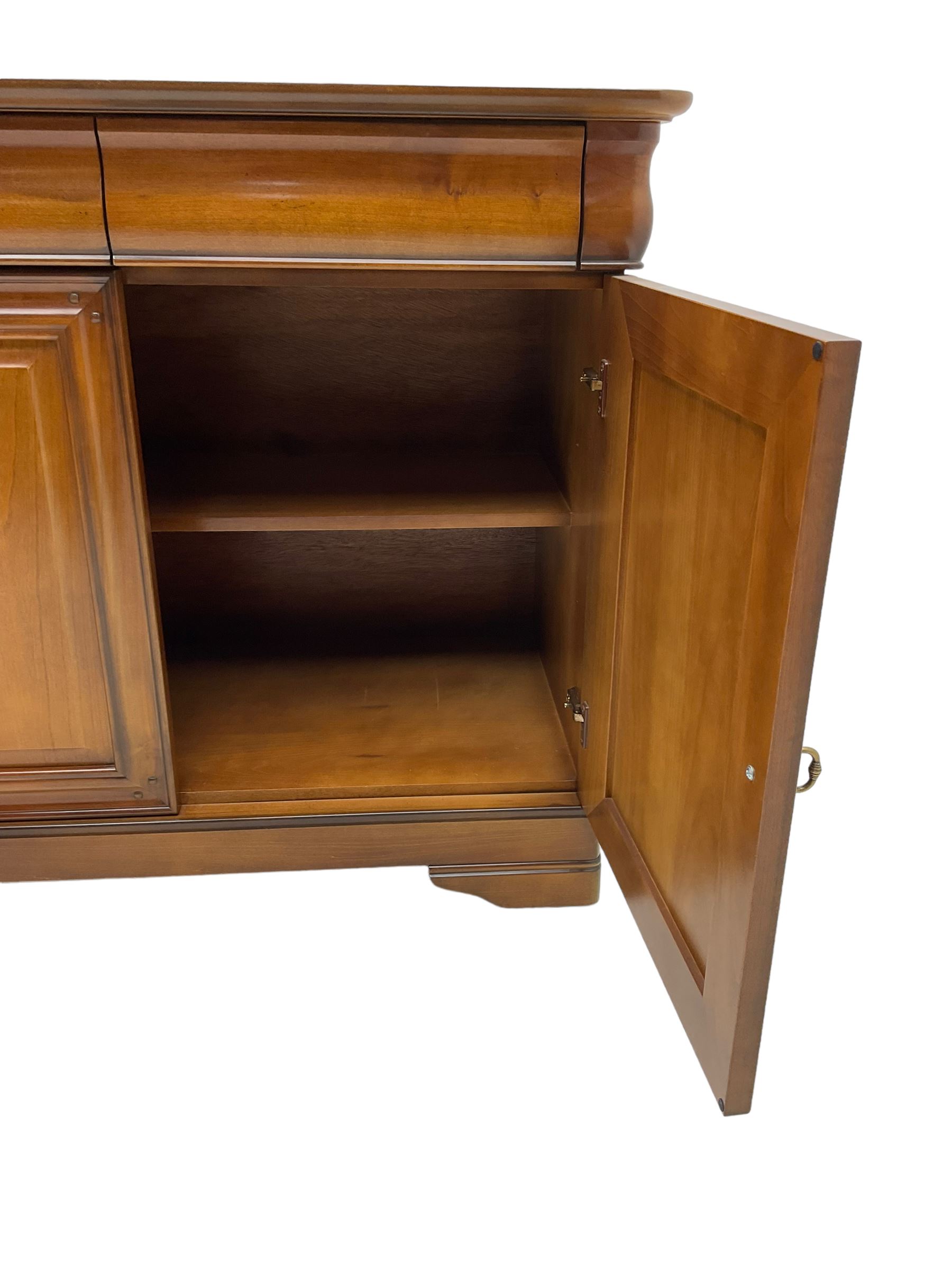 Cherry wood sideboard, fitted with three cushion drawers over three panelled cupboard doors, on bracket feet