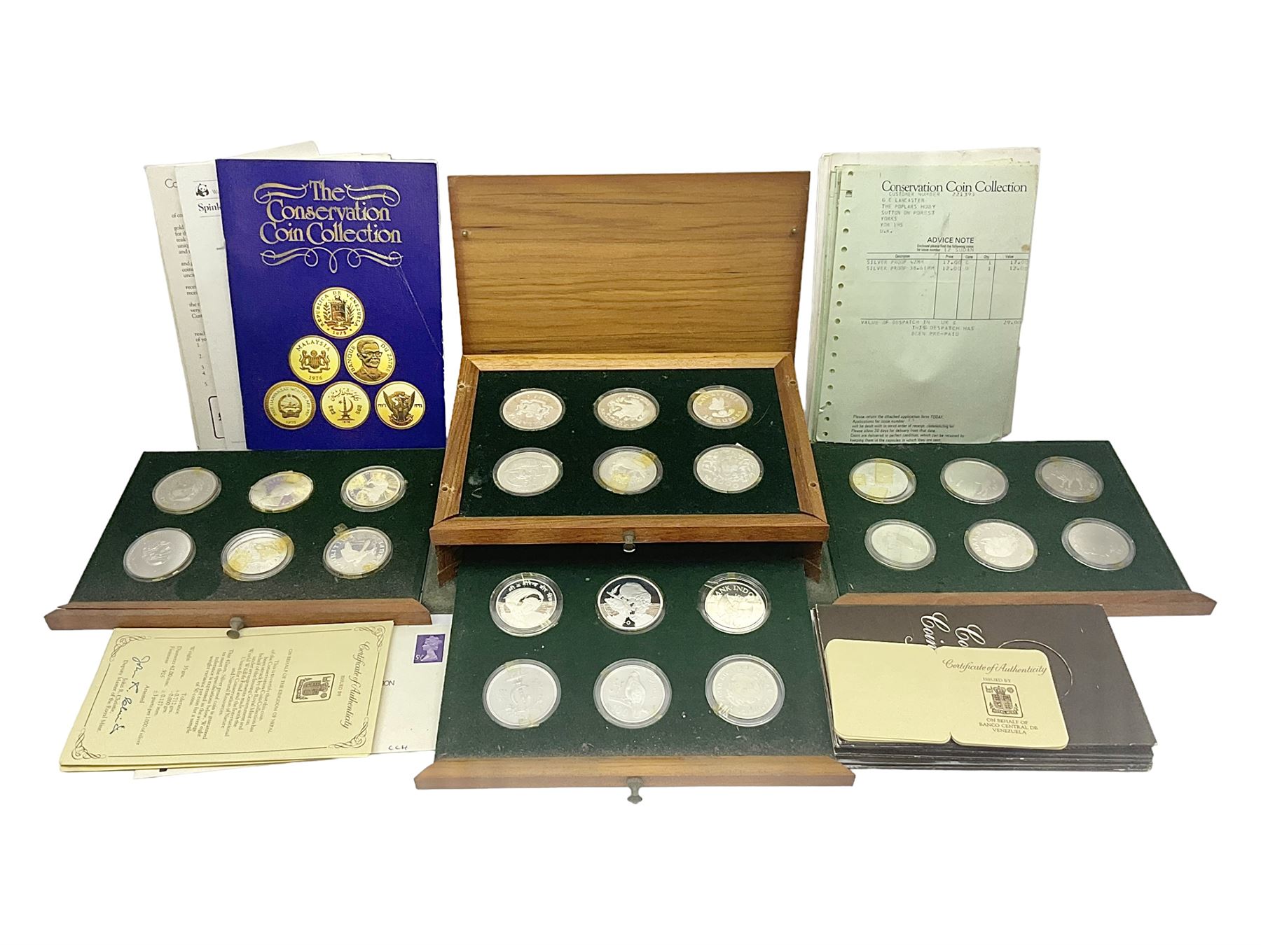 The Royal Mint 'Conservation Coin Collection' formed of twenty-four silver proof coins, housed in the wooden display case, with information booklet