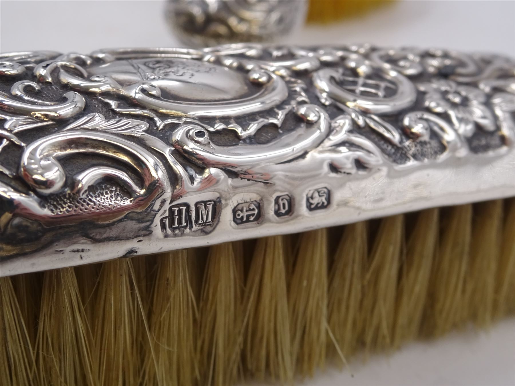 Group of silver, comprising Victorian silver hair brush and matching clothes brush, with repousse floral and scroll decoration, and each engraved with lion rampant to central cartouche, hallmarked Henry Matthews, Birmingham 1895, together with a 1920s miniature silver mounted photograph frame, hallmarked Charles Edwin Turner, Birmingham 1925 H7cm, and a Georgian silver Hanoverian pattern teaspoon, with scroll decoration to underside of bowl and engraved initials verso, hallmarks worn and indistinct