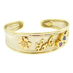 18ct gold 'Love' torque bangle, set with a heart cut pink sapphire and blue topaz, stamped Sidra 750