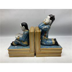 Pair of 20th century Chinese figural bookends, modelled as children in traditional blue dress sat reading and kneeling upon stacks of books, H22cm