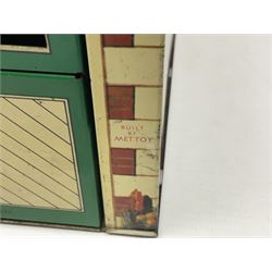 Mid-20th century Mettoy tin-plate double-fronted two-storey doll's house, the front elevation with five unglazed windows flanked by green shutters, central opening door, open back giving access to five rooms together with an attached garage, 60cm wide