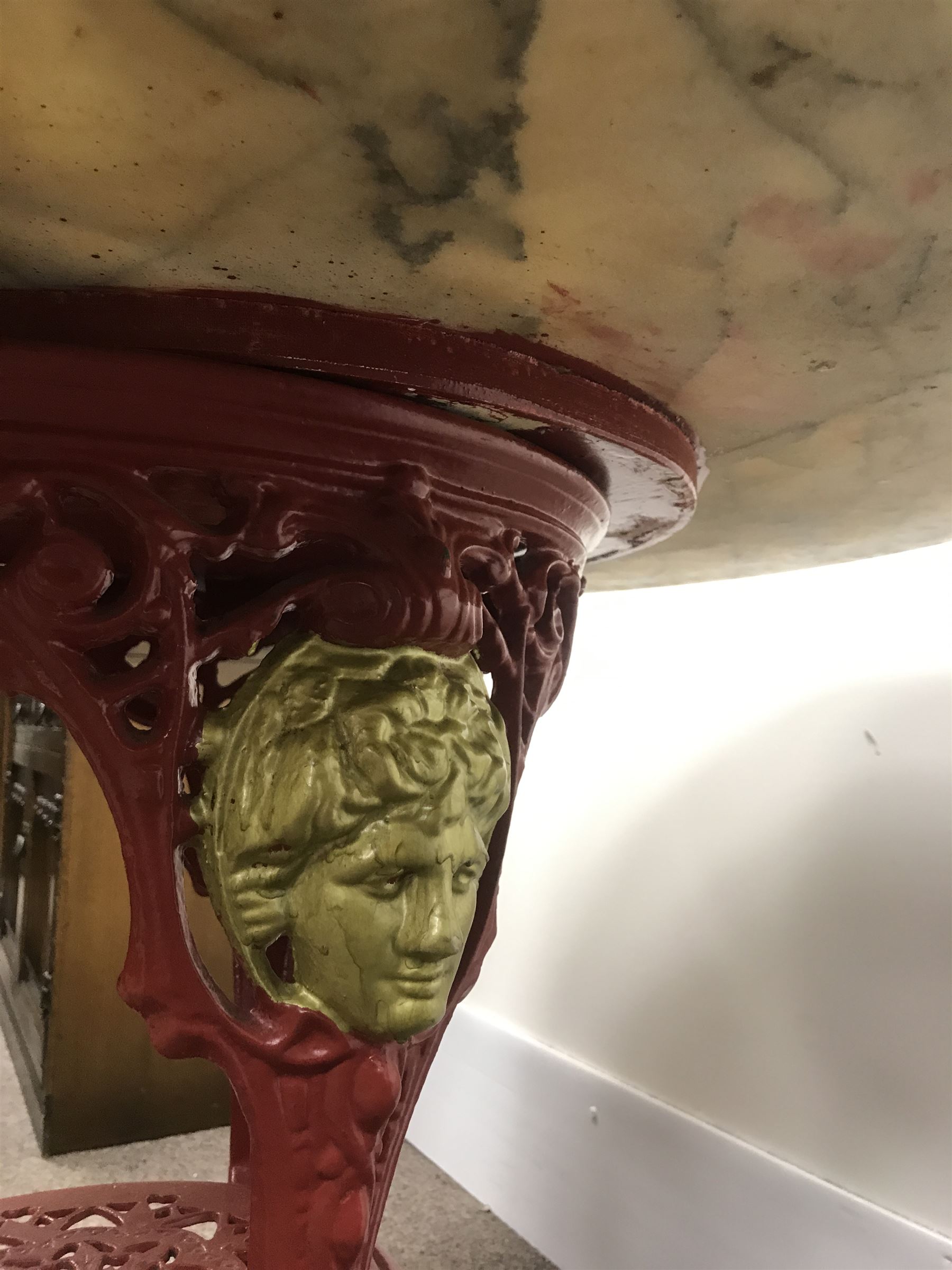 Pair cast iron Britannia pub tables, one red, one black with large marble tops 