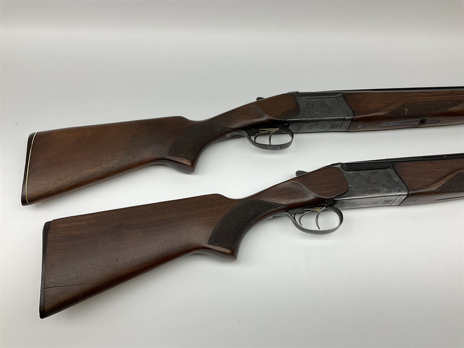 Two Russian Baikal 12-bore over-and-under double barrel boxlock non-ejector sporting guns; one with 68.5cm barrels, walnut stock with chequered pistol grip and fore-end and thumb safety, serial no.520545, L111cm overall; the other with 72.5cm barrels, walnut stock with chequered pistol grip and fore-end and thumb safety, serial no.012448, L114.5cm overall (2) SHOTGUN CERTIFICATE REQUIRED