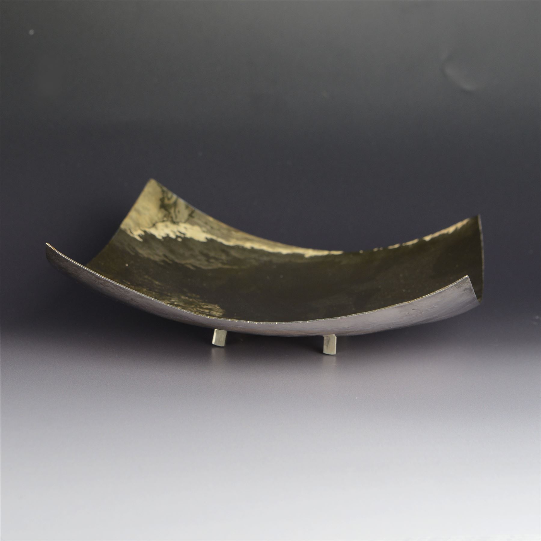 Modern silver bowl, of square concave form, with gilt interior and gilt spiral decoration to underside, with planished decoration throughout, upon four column feet, hallmarked Jonathan Braganza, London 2013, H5cm, W18cm