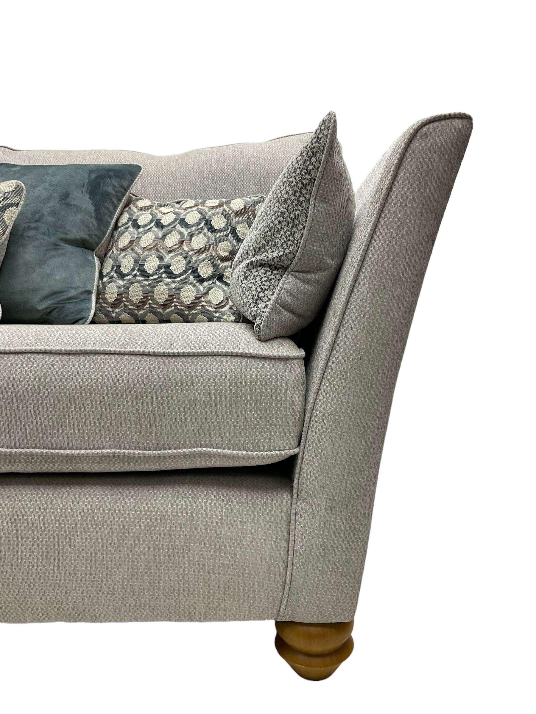 Oak Furnitureland - 'Gainsborough' lounge suite - three seat sofa, out-swept arms with loose cushions on turned oak feet, upholstered in 'Minerva Silver' fabric (W209cm D102cm H80cm); matching armchair or snuggler settee (W125cm); and rectangular ottoman footstool