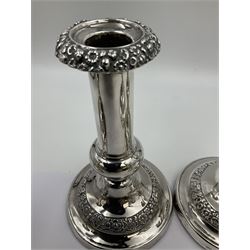 Four George III silver candlesticks, each upon knopped stem and weighted circular stepped foot, the foot and removable sconce repousse decorated with a band of flower heads, hallmarked to sconce and foot Thomas & John Settle, Sheffield 1820, H17.5cm
