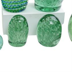 Eleven Victorian and later green glass dump paperweights, with floral and bubble inclusions, largest H14cm 