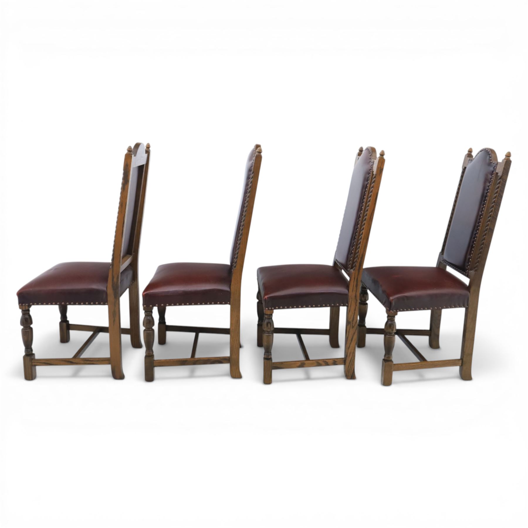 Carolean revival oak dining table and eight chairs (7+1), refectory table with rectangular boarded top and cleated ends, raised on shaped trestle end supports with central stretcher, accompanied by eight high-back chairs including a carver, leather upholstered panels and seats with studwork, on turned legs with stretchers.