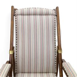 Pair of early 20th century oak framed garden reclining and folding deckchairs, high back and seat upholstered in striped fabric with padded armrests