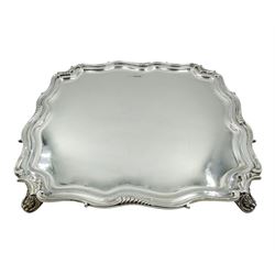 1930's silver salver, of square form with shaped and scrolled rim, upon four foliate splayed feet, hallmarked Walker & Hall, Sheffield 1930, D27.5cm, approximate weight 32.98 ozt (1026 grams)
