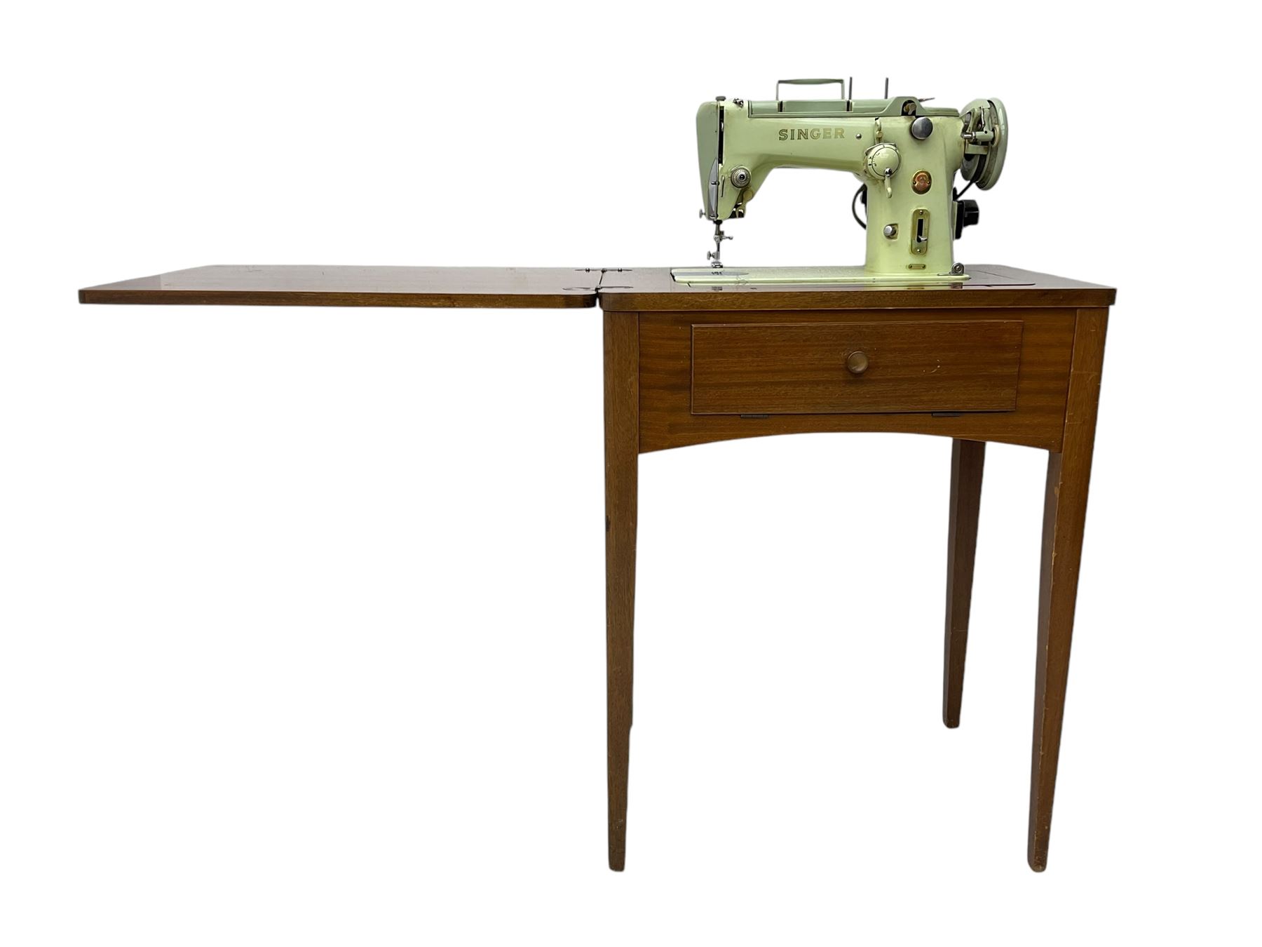 Mid-20th century teak sewing table, rectangular top with hinged fold-out extension revealing built-in Singer sewing machine, fitted with single hinged drawer, on square tapered supports; various Singer accessories to include Fashion Discs and Motor Controller