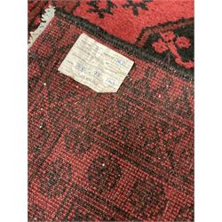 Afghan Bokhara rug, red ground and decorated with three Gul motifs, geometric design borders decorated with flower heads
