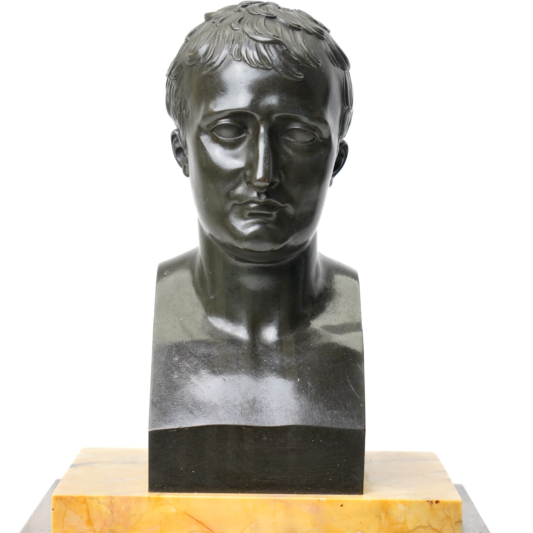 French-First quarter 19th century 8-day sienna marble and bronze-mounted mantel clock of rectangular architectural form, with patinated foliate guilloche pattern cast bronze mounts  in richly figured sienna marble, surmounted a by a classical patinated bronze bust of Napoleon Bonaparte, above a gilt engine turned dial with Roman numerals and blued steel hands, with a twin train Parisian countwheel striking movement, striking the hours and half-hours on a bell, silk suspension with thumb-screw adjustment. With pendulum.