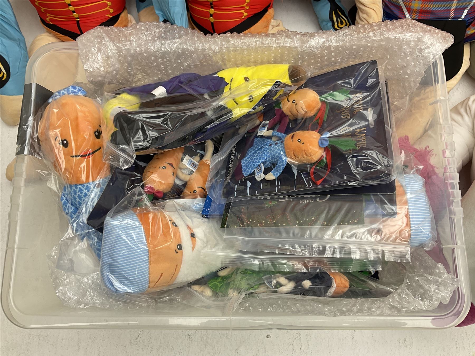 Three large ALDI Kevin carrots and giant unicorn stuffed toy together with quantity of smaller carrots