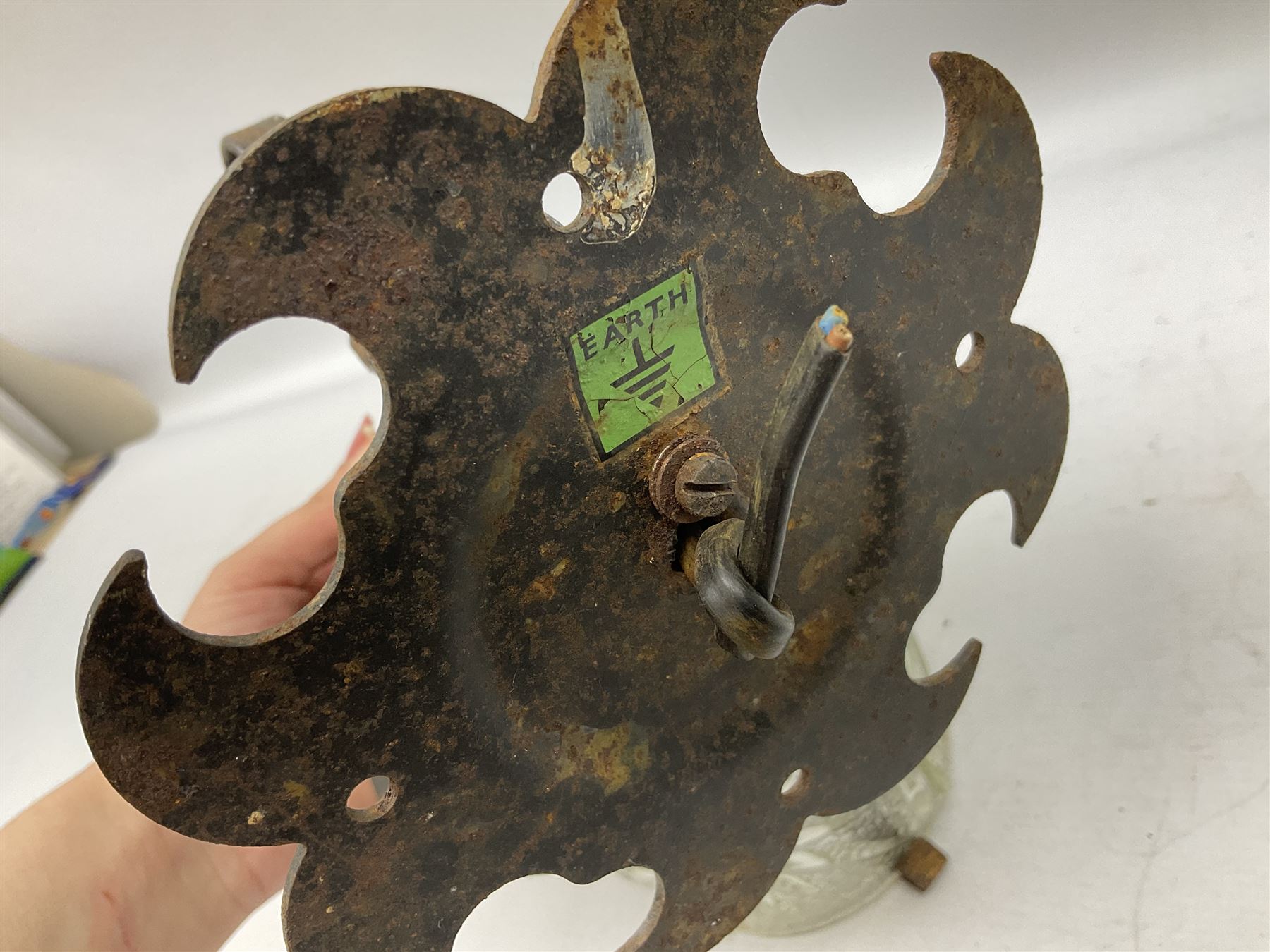 Wrought iron wall lantern with patterned glass shade of tapering cylindrical form, H29cm