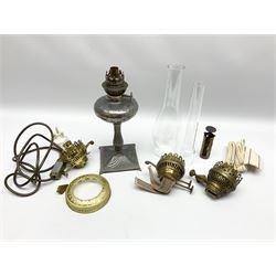 Small spelter oil lamp, together with various oil lamp accessories including a clear glass chimney, in one box 