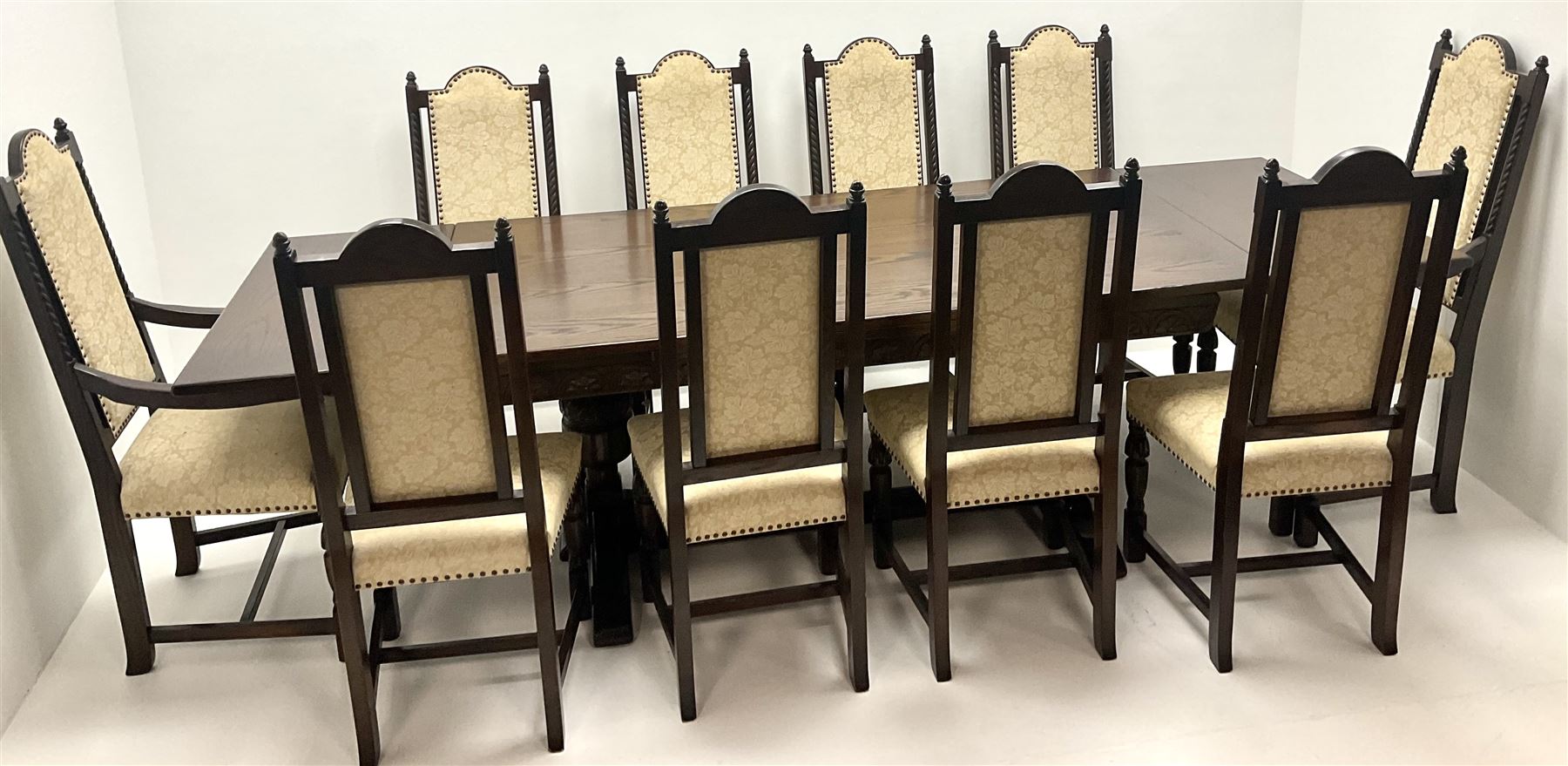 Jacobean style medium oak refectory dining table on cup and cover supports joined by single floor stretcher (W274cm, H77cm, D92cm) and set ten (8+2) high back dining chairs, studded upholstered back and seat, turned supports (W57cm)