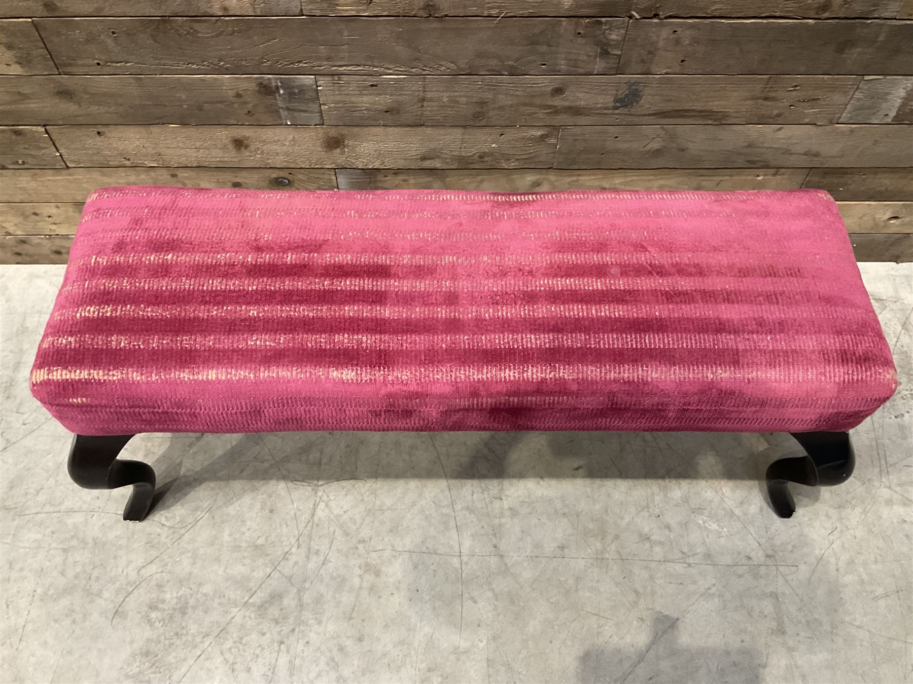 Large rectangular footstool upholstered in a maroon fabric with cabriole supports