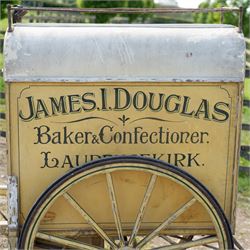 James I. Douglas, Baker & Confectioner, Laurencekirk Hand Drawn Delivery Cart

An attractive late 19th or early 20th century hand drawn baker's delivery cart, finished in cream and retaining its original hand painted advertising livery for James I. Douglas, Baker & Confectioner, Laurencekirk. The enclosed body features a curved roof with external luggage rail, rear access doors and internal shelving for the transport and delivery of bread, cakes and confectionery. Mounted on large wooden spoked wheels with iron tyres and fitted with shaped shafts for a single horse, this is a highly decorative and increasingly scarce example of a provincial tradesman's delivery vehicle, offering excellent display potential for collectors, museums, period interiors or commercial settings.

Features:
• Original hand painted signwriting for James I. Douglas, Baker & Confectioner, Laurencekirk
• Enclosed delivery body with curved roof and external luggage rail
• Rear opening access doors with internal storage compartments
• Original internal wooden shelving and racks
• Large wooden spoked wheels with iron tyres
• Shaped shafts for single horse traction
• Builder's mark for Geo. Roberson Ltd., Wallington
• Decorative cream painted finish with period lining and detailing
• Suitable as a display piece, museum exhibit or advertising feature

Dimensions:
Overall length: 170 cm
Body length: 104 cm
Width: 83 cm
Height: 150 cm

Wheel Diameter:
Wheels: 95 cm