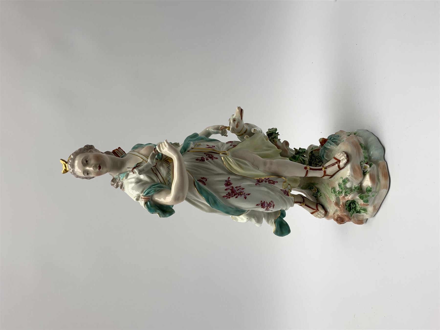 Mid 18th century Derby porcelain figure modelled as Dianna the Huntress, with quiver of arrows upon her back and dog by her side, upon a naturalistically modelled base, with patch marks beneath and collectors labels, H26cm