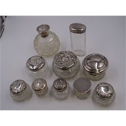 Mid 20th century silver topped cut glass scent bottle, with hobnail and octagonal decoration to the glass body, the silver lid repousse decorated with putti, hallmarked Boots Pure Drug Company, Birmingham 1943, together with nine silver topped glass dressing table jars, with designs including butterfly and romantic scene,  all with hallmarked with various makers and dates
