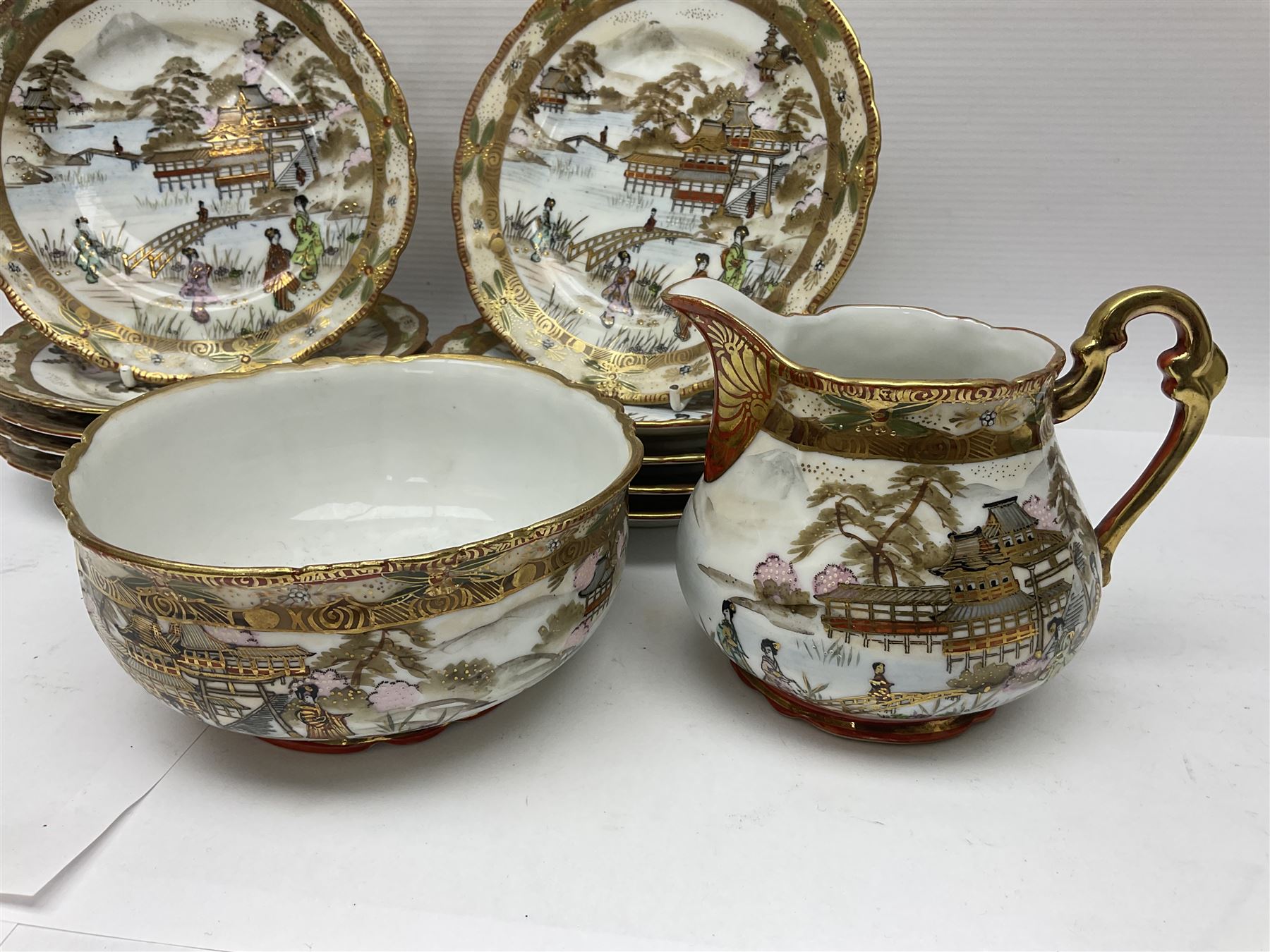Noritake part tea service, printed and painted with figures in a landscape, comprising ten  tea cups and saucers, ten dessert plates, milk jug and sugar bowl