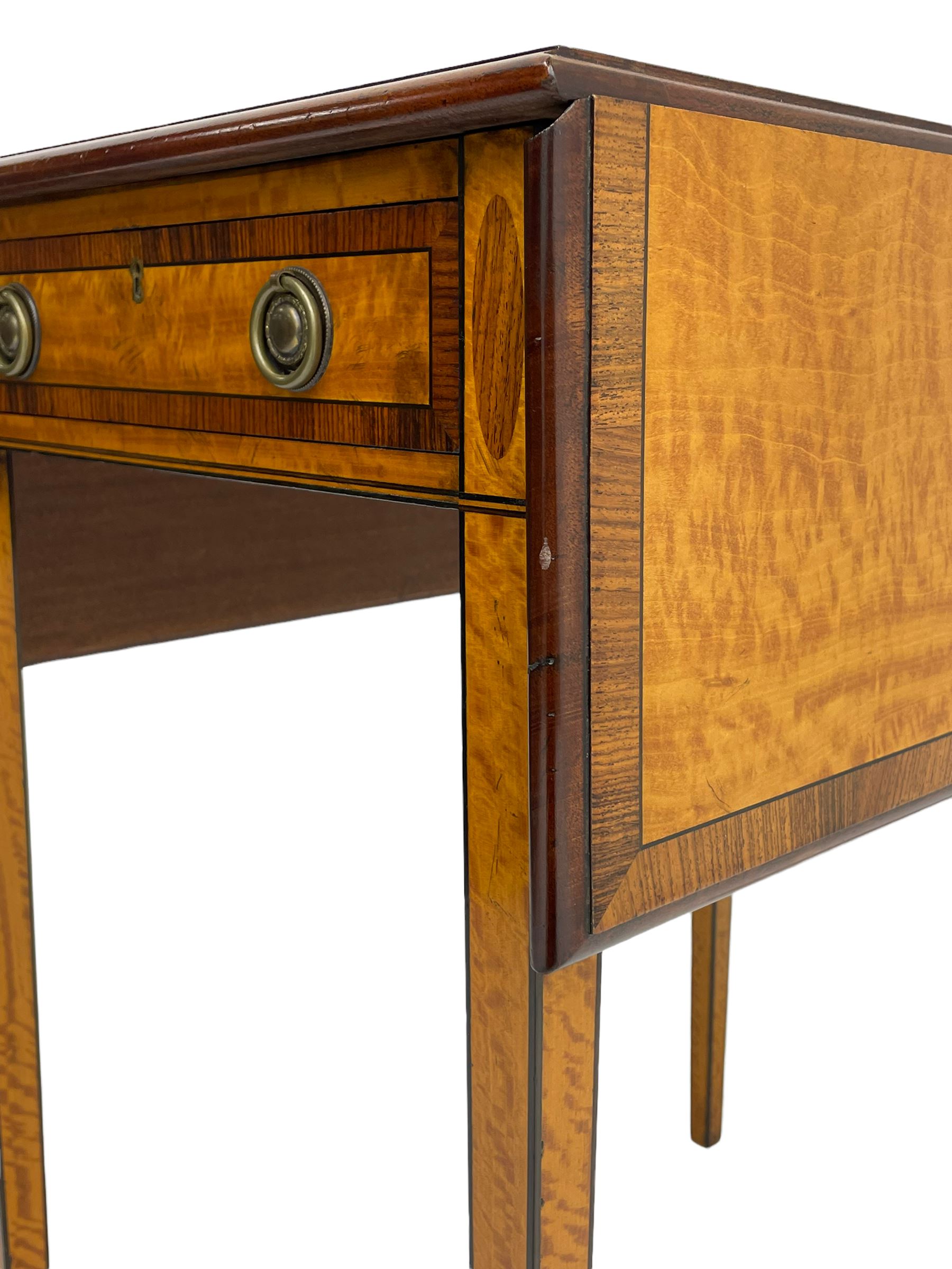 Mid-to-late 20th century Sheraton style satinwood Pembroke table, the drop leaf top with segmented veneers and central oval panel with ebony stringing, crossbanded in rosewood and with edge moulding, single short drawer to one end and faux drawer to other, square tapering supports