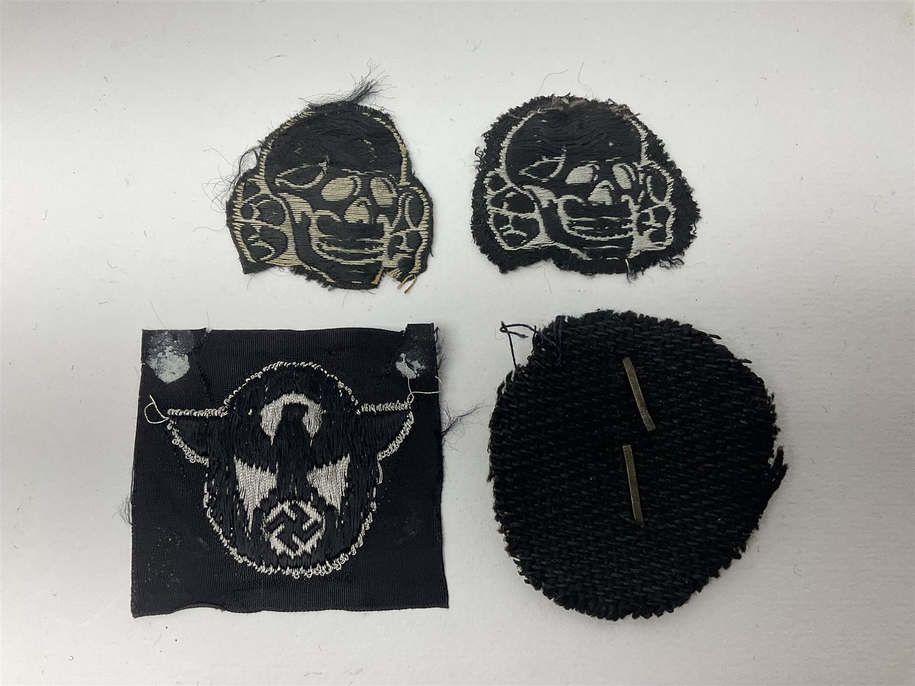 Collection of eleven German metal and cloth badges and uniform buttons including driver's badge, two 'SS' fabric skulls, private's shoulder tabs, Police cloth badge, tank destruction badge, medal bars and ribbon etc; most WW2 period