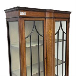 Edwardian inlaid mahogany display cabinet, enclosed by two astragal glazed doors, bowed centre inlaid with ribbon and trailing bellflowers, on square tapering supports with spade feet united by undertier 