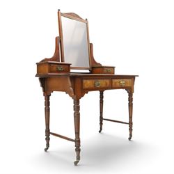 Late Victorian figured walnut and mahogany dressing table, raised swing-mirror back over trinket drawers, fitted with two drawers with brass Aesthetic Movement handles, on ring-turned supports with ceramic castors