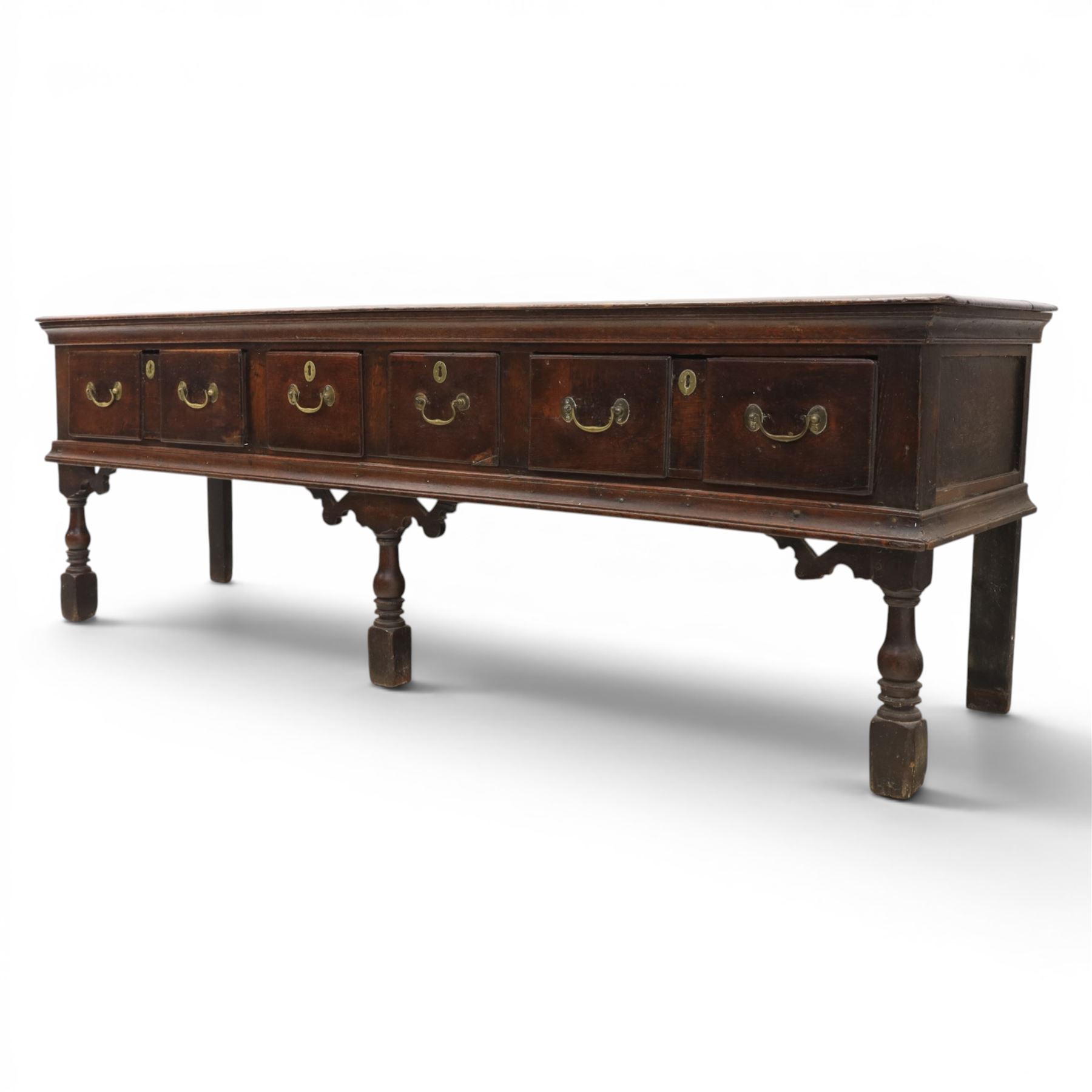 17th century 8’ oak dresser base with moulded front, rectangular top, above four drawers, raised on turned and block support 
