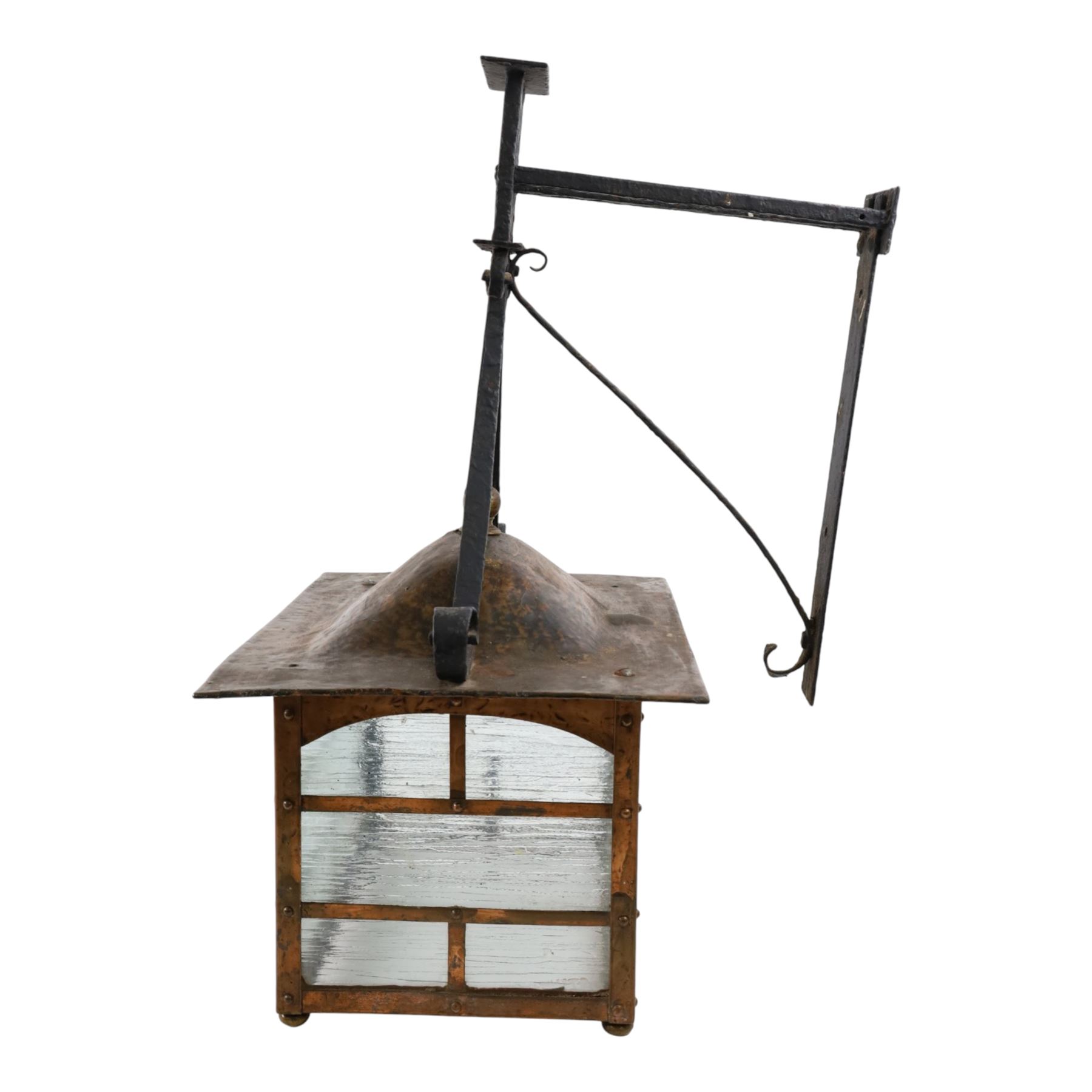 20th century, Arts and Crafts style copper porch lantern, of rectangular form, with cast iron scrolling wall fittings