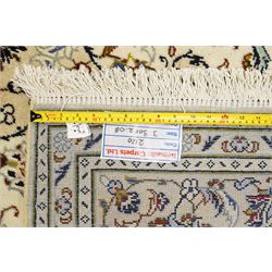 Central Persian Kashan hand-knotted carpet, ivory field with central lobed medallion issuing an all-over design of scrolling vines, palmettes, and floral sprays, within conforming spandrels, enclosed by a foliate border, framed by multiped guard stripes, with cotton fringe ends 