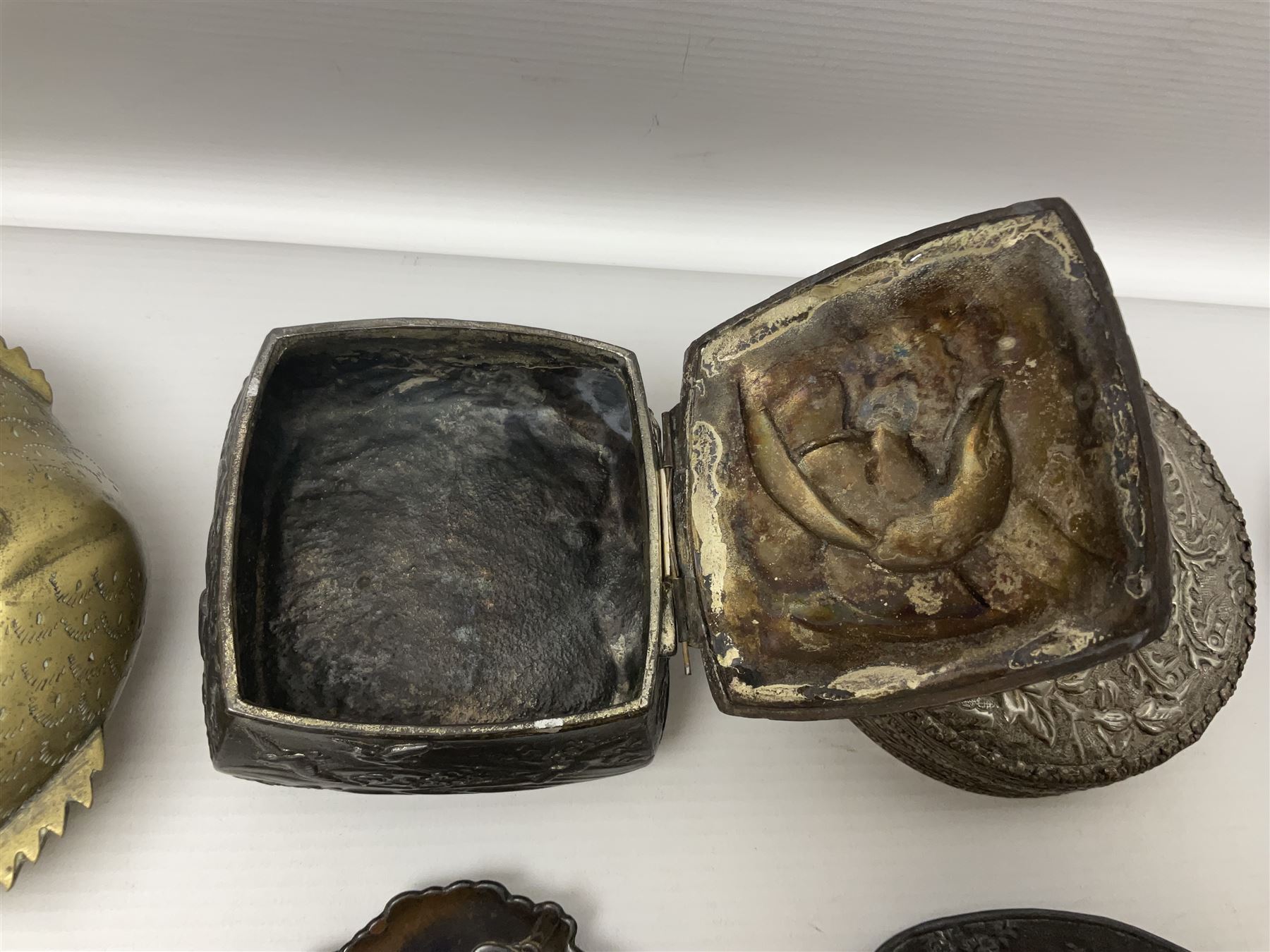 Brass sunfish ashtray, Chinese silver plated trinket box with mirror, bronzed matchbox cover and a collection of other Oriental bronzed embossed metal trays