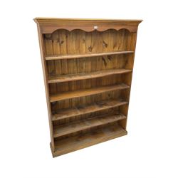 Large pine open bookcase, projecting cornice and shaped frieze over five shelves