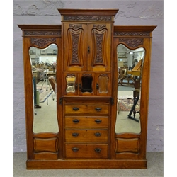  Edwardian walnut triple combination wardrobe, projecting cornice, carved foliage frieze, two shaped mirror doors enclosing fitted interior flanking central panelled cupboards above three glazed doors and four graduating drawers on plinth base, W196cm, H225cm, D64cm  