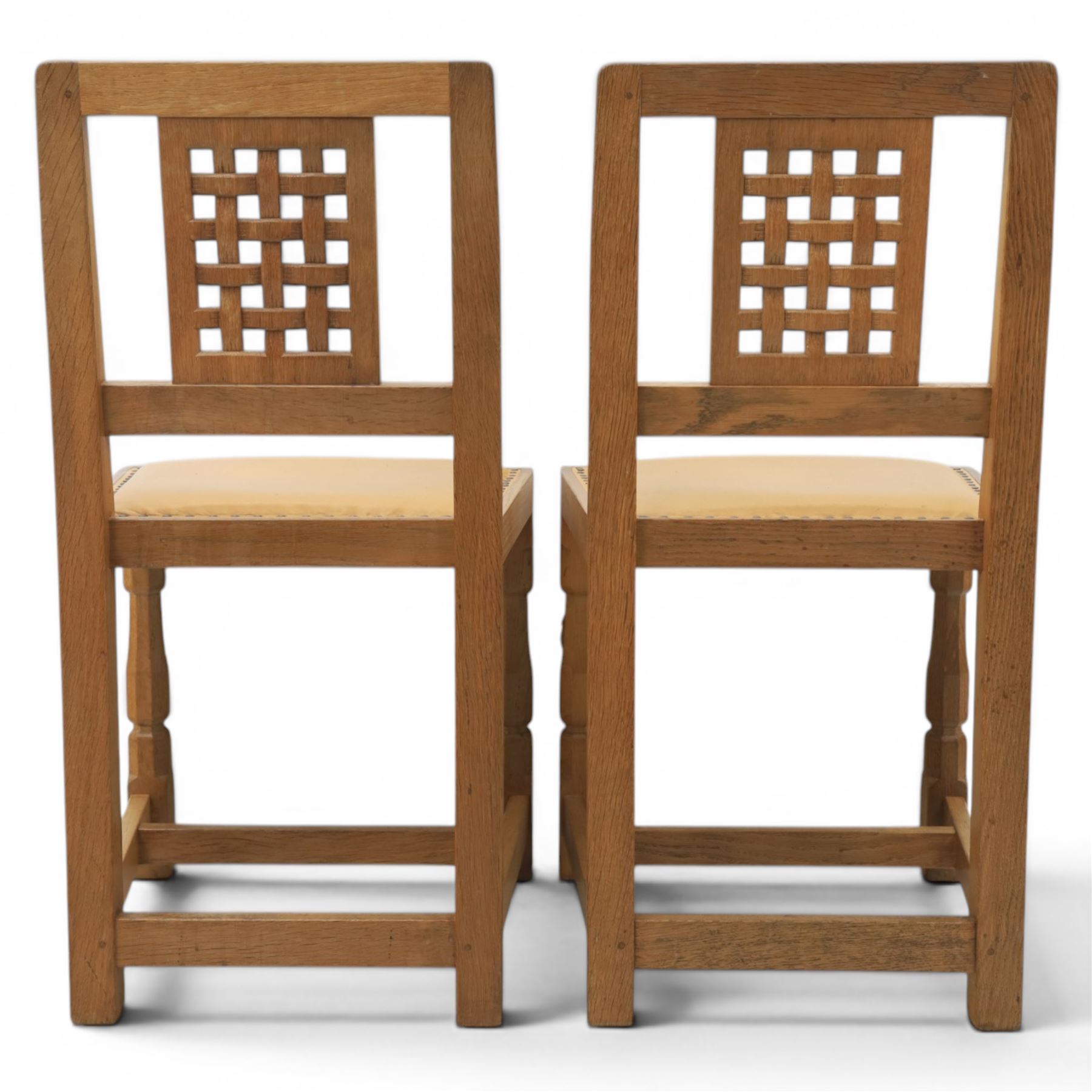 Mouseman - set of four oak lattice back chairs with tan seat with brass studded trim, with carved mouse signature, by the workshop of Robert Thompson of Kilburn
