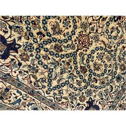 Persian Kashan ivory ground rug, wool with silk inlay, central floral rosette medallion surrounded by trailing flower heads and interlacing leafy branches, the repeating scrolling border decorated with palmettes, within guard stripes